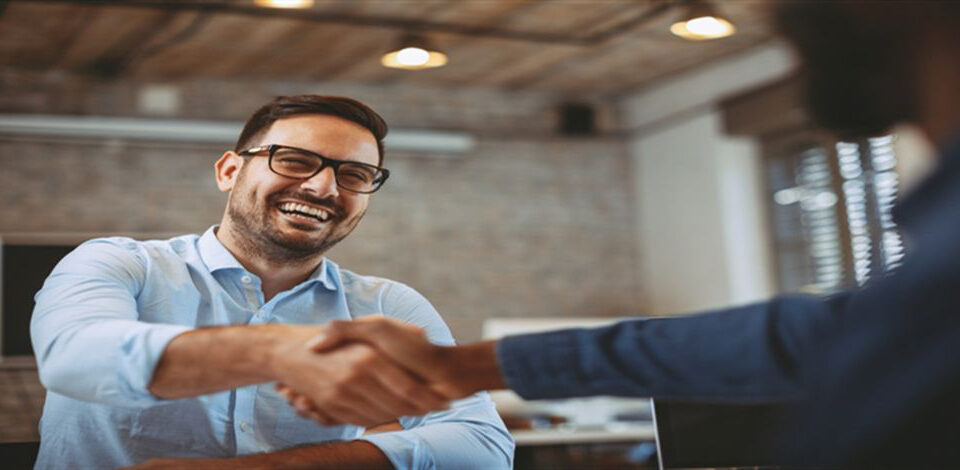 Smiling man making a deal with a handshake